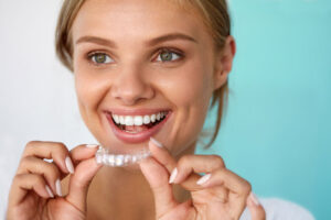 Smiling Woman With Beautiful Smile Using Teeth Whitening Tray.