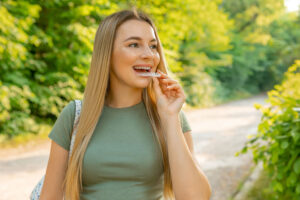 a cosmetic dental patient holding a clear aligner