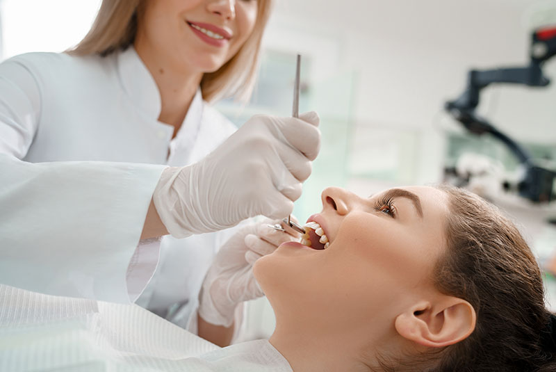 Female patient lying on dental chair with open mouth