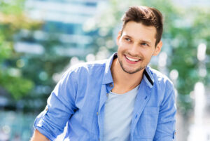 young male smiling brightly while being outside